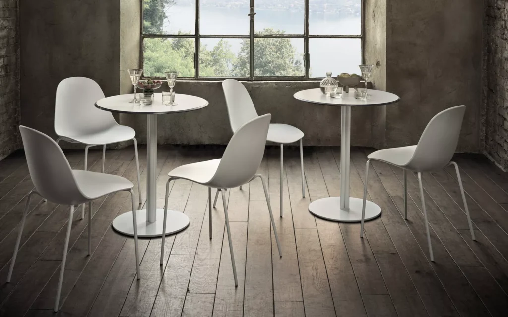 Sedie Bontempi Mood bianche e tavolini tondi bianchi su parquet scuro