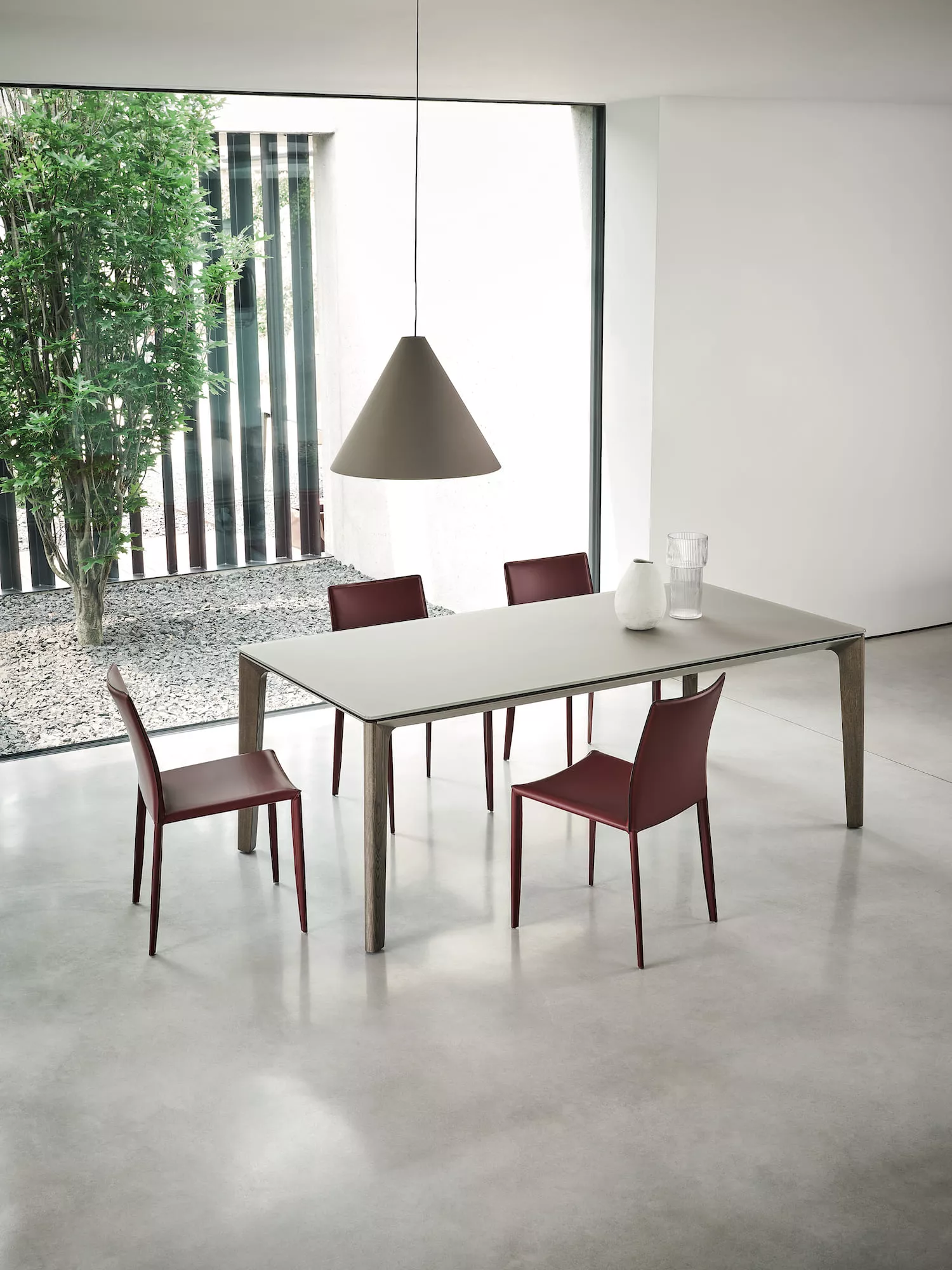 Sedie Linda di Bontempi rivestite in cuoio bordeaux intorno a un tavolo da pranzo