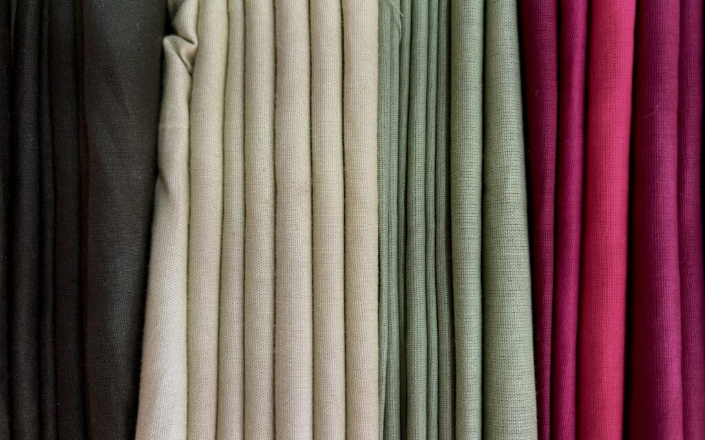 Campioni di tessuto drappeggiati in nero, panna, verde salvia e magenta